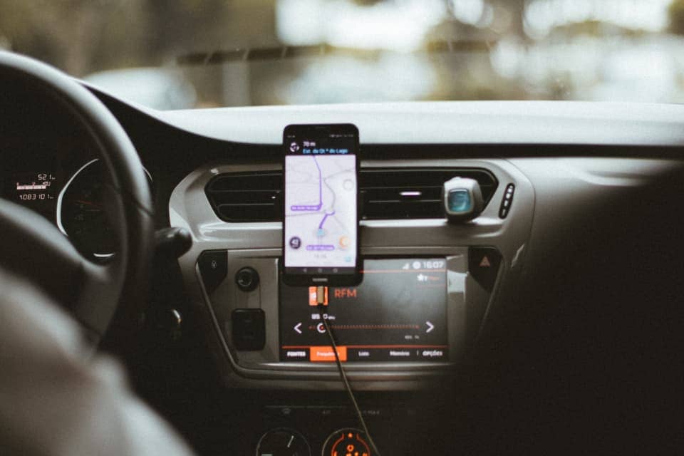 Driver with smartphone, by Humphrey Muleba from Unsplash